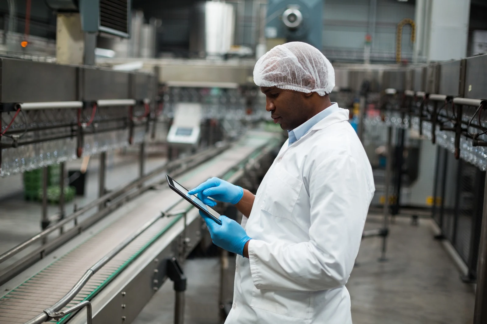 Manufacturing professional using a tablet on the factory floor.